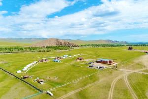 an aerial view of a large green field with horses at Tungalag tamir tourist camp 