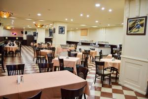 una sala da pranzo con tavoli e sedie in un ristorante di Sana Ski apartment 620 in Flora, Borovets a Borovets