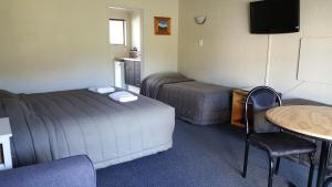 a hotel room with two beds and a table at Ruapehu Mountain Motel & Lodge in Ohakune +194 photos