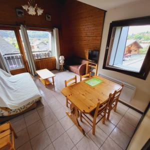 een woonkamer met een houten tafel en een bank bij Superbe appartement au centre de Samoens in Samoëns