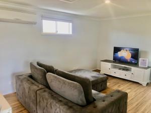 a living room with a couch and a flat screen tv at MULBERRY LODGE in Woodridge