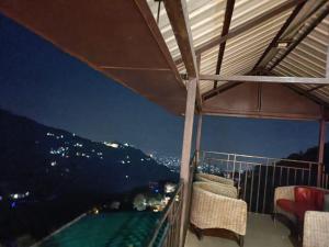 a balcony with chairs and a view of the city at Hotel The King near mall rd mcleodganj in Dharmsāla