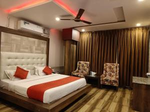 a bedroom with a large bed and two chairs at Hotel The King near mall rd mcleodganj in Dharmsāla