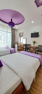 - une chambre avec 2 lits et un plafond violet dans l'établissement Pink house Homestay, à Hội An