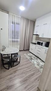 a living room with a table and a kitchen at Квартира в новом жилом комплексе Invest House in Tashkent