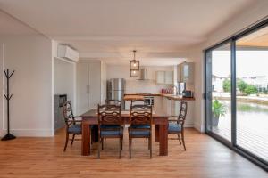 cocina y comedor con mesa de madera y sillas en Port Lane Lower Apartment, en Geographe
