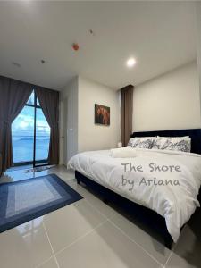 a bedroom with a bed with the shore by africa written on it at The Shore Kota Kinabalu by Ariana in Kota Kinabalu