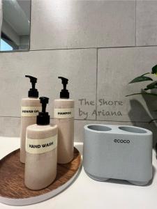 three bottles of soap on a tray on a bathroom counter at The Shore Kota Kinabalu by Ariana in Kota Kinabalu