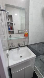 bagno bianco con lavandino e specchio di Квартира в новом жилом комплексе Invest House a Tashkent