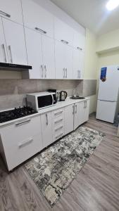 a kitchen with white cabinets and a white refrigerator at Квартира в новом жилом комплексе Invest House in Tashkent