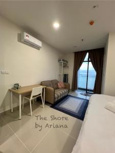 ein Schlafzimmer mit einem Bett, einem Schreibtisch und einem Sofa in der Unterkunft The Shore Kota Kinabalu by Ariana in Kota Kinabalu
