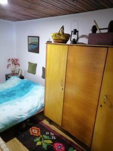 um quarto com uma cama e um armário de madeira em Kućica za odmor-Borova glava em Zlatibor