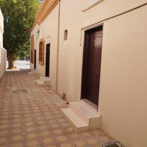 une allée avec une porte et des marches à côté d'un bâtiment dans l'établissement العين الهيلي مصباح بيت 3, à Al-Aïn