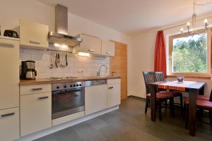 瑟尔Bichler Katrin, Ferienwohnung的带桌子的厨房和餐厅