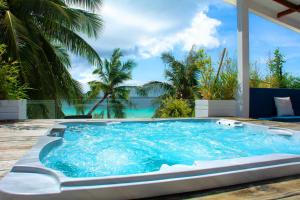 una piscina con vistas al océano y a las palmeras en Mayumi Beach Villa en Boracay