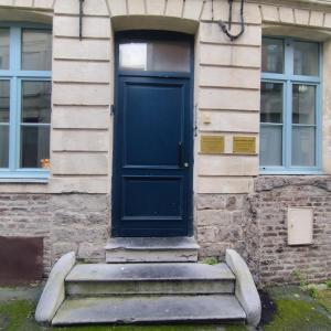 une porte bleue sur le côté du bâtiment dans l'établissement "La cour du Noble" Hypercentre cour privative, à Arras