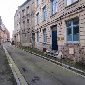 un bâtiment avec une porte bleue sur le côté d'une rue dans l'établissement "La cour du Noble" Hypercentre cour privative, à Arras