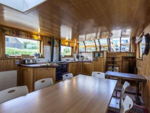 a dining room with a wooden table and chairs at Cushy Boat in Merkem with Terrace in Drie Grachten