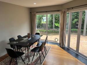 a dining room with a black table and chairs at Marvelous Munro in Hamilton