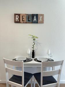 een witte tafel met twee stoelen en een bord aan de muur bij Madeiran Sweet Home in Funchal