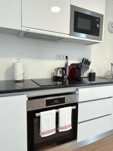 a kitchen with a stove top oven with two white towels at Madeiran Sweet Home in Funchal