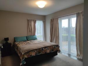 ein Schlafzimmer mit einem Bett und einem großen Fenster in der Unterkunft Marvelous Munro in Hamilton