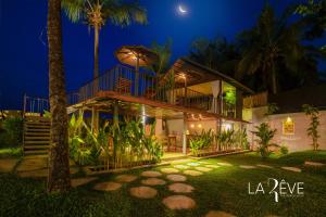 uma casa com varanda à noite em LA RÊVE The Beach Villa em Malappuram