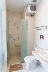 a bathroom with a shower and a toilet and a sink at Miko Rooms & Capsules hotel in Bungurasih