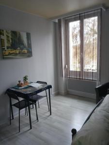 een kamer met een tafel en stoelen en een bed bij Studio du Parc thermal in Vittel