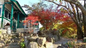 una casa con una recinzione di roccia davanti di 鉢巻山荘 a Omura