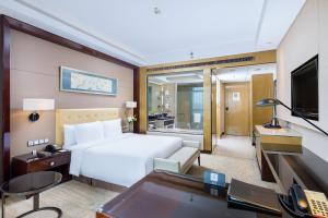 a bedroom with a bed and a desk and a television at Wanda Realm Taizhou in Taizhou