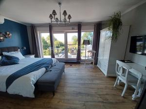 una camera da letto con un letto, una scrivania e una televisione di B&B La source de notre Manon a Jauche