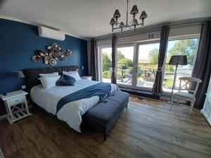 una camera da letto con un letto grande con una parete blu di B&B La source de notre Manon a Jauche