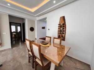 a dining room with a wooden table and chairs at Abilia Apt - À Proximité de l'Aéroport - Parking gratuit et Wi-Fi rapide in Sukrah