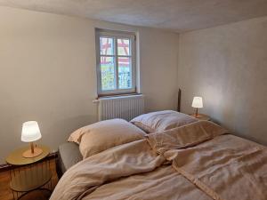 a bed in a bedroom with two lamps on tables at Alte Schmiede Buckow in Buckow