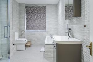 a white bathroom with a sink and a toilet at Charming 3BD Cotswolds Family Retreat in Bourton on the Water