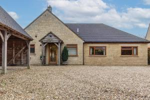 a large brick house with a large driveway at Charming 3BD Cotswolds Family Retreat in Bourton on the Water