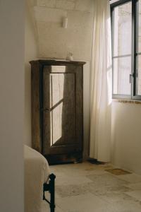 - une chambre avec une porte en bois et une fenêtre dans l'établissement Palazzo Bergamotti, à Ostuni