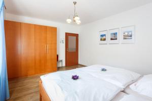 リプノ・ナト・ヴルタヴォウにあるVila Kubik Lipnoのベッドルーム(白いベッド2台、木製キャビネット付)