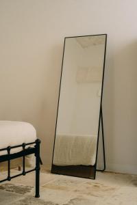 - un miroir à côté d'un lit dans la chambre dans l'établissement Palazzo Bergamotti, à Ostuni