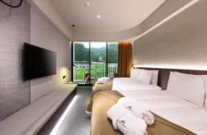 2 camas en una habitación de hotel con TV de pantalla plana en 歸璞泊旅 Hotel Beore en Yuchi