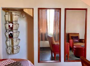 a bedroom with a mirror and a room with a chair at Kalanchoe Poshtel Suites in Las Palmas