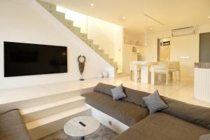 un soggiorno con divano e TV a schermo piatto di Sore Pererenan Residence Unit 1 a Canggu