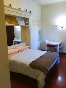 a bedroom with a bed and a table and a desk at APPARTAMENTO GALLO in Brescia
