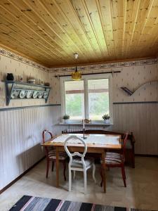 uma sala de jantar com uma mesa de madeira e cadeiras em Stuga Näsberget em Malung