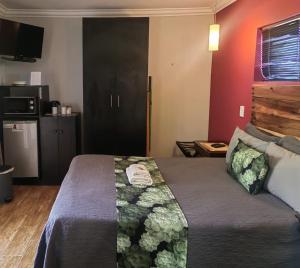 a hotel room with a bed with a green blanket at @47 Galpin in Port Elizabeth