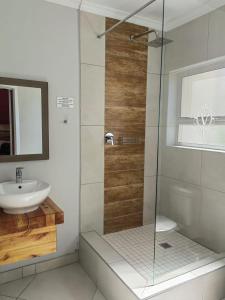 a bathroom with a glass shower and a sink at @47 Galpin in Port Elizabeth