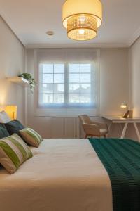 Un dormitorio con una cama grande y una ventana. en AH Delux3Rooms Campus Milán VUT6519AS, en Oviedo