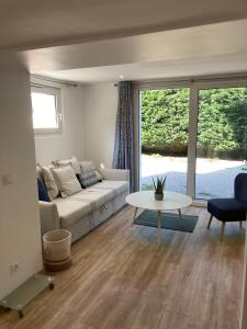 a living room with a couch and a table at Appartement T2 rez de chaussée villa Les Tamaris Aix-les-Bains in Aix-les-Bains