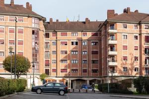a car parked in front of a large building at AH Delux3Rooms Campus Milán VUT6519AS in Oviedo